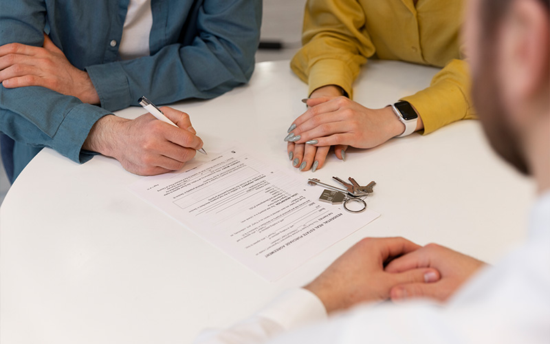 People signing a real estate purchase agreement.