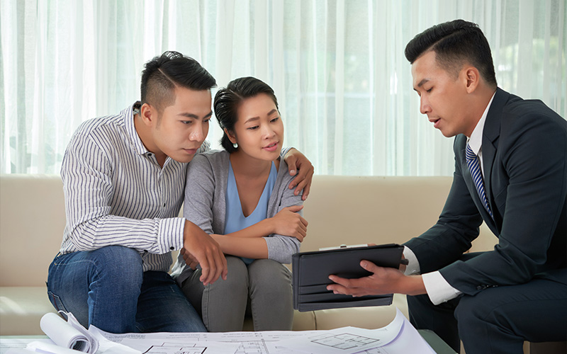 Property agent discussing appraisal with a couple.