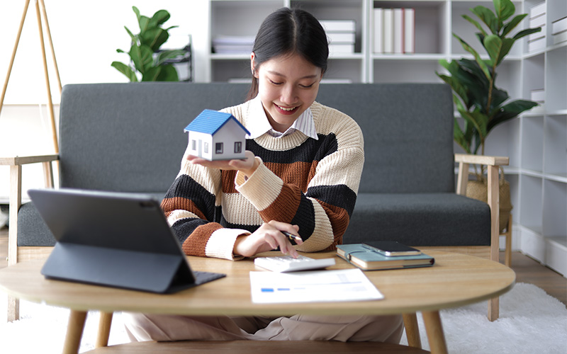 Woman calculating property value for a house.