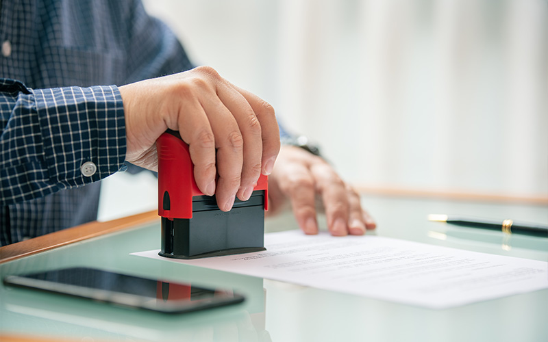 Hand stamping a property valuation document.