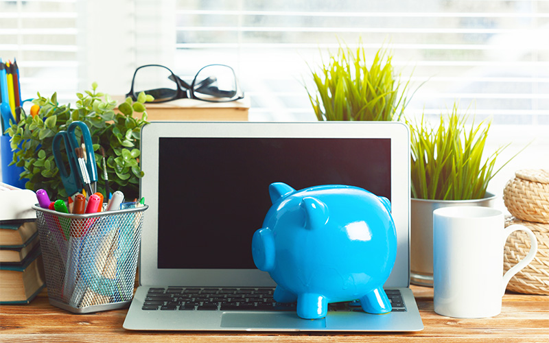 Piggy bank on laptop for property valuation.