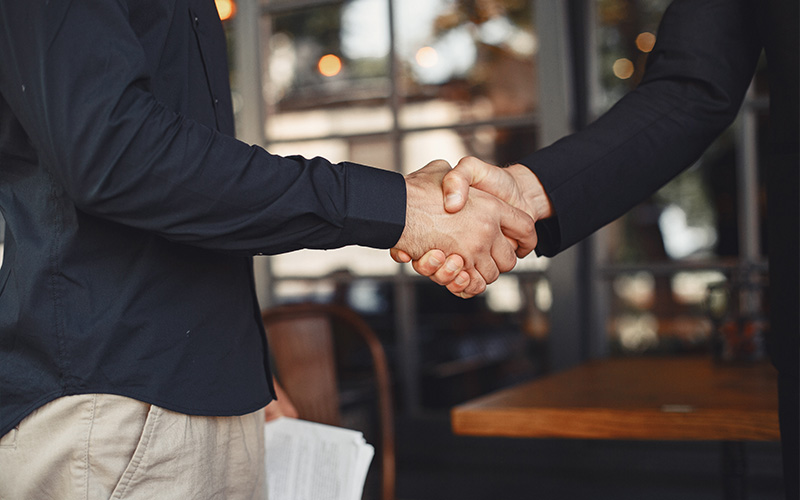 Property valuers shaking hands on a deal.