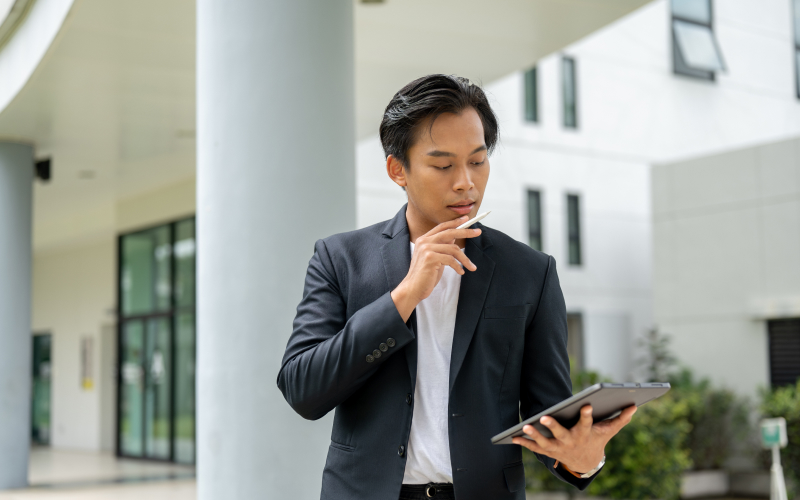 Real estate agent reviewing property market value on tablet.